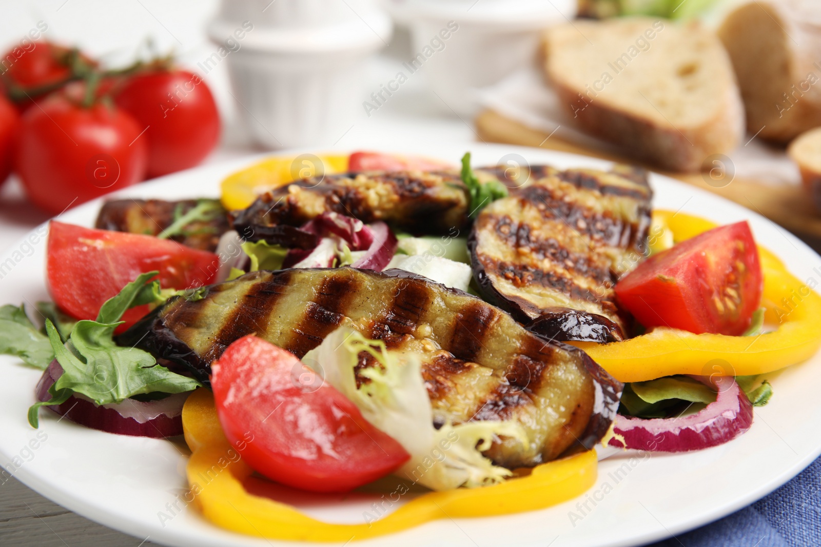 Photo of Delicious salad with roasted eggplant on plate, closeup