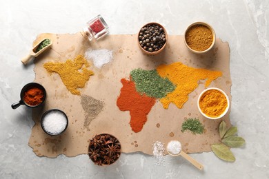 Photo of World map of different spices and products on light grey marble table, top view