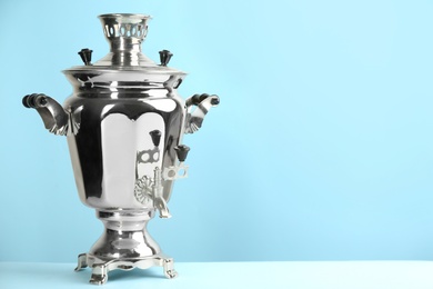 Photo of Traditional Russian samovar on light blue background. Space for text