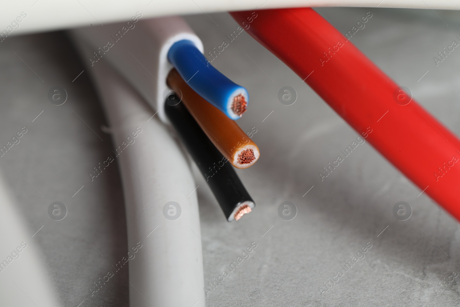 Photo of Colorful electrical wires on gray surface, closeup