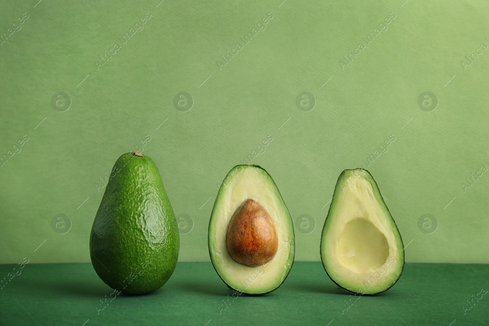 Photo of Composition with ripe avocados on color background