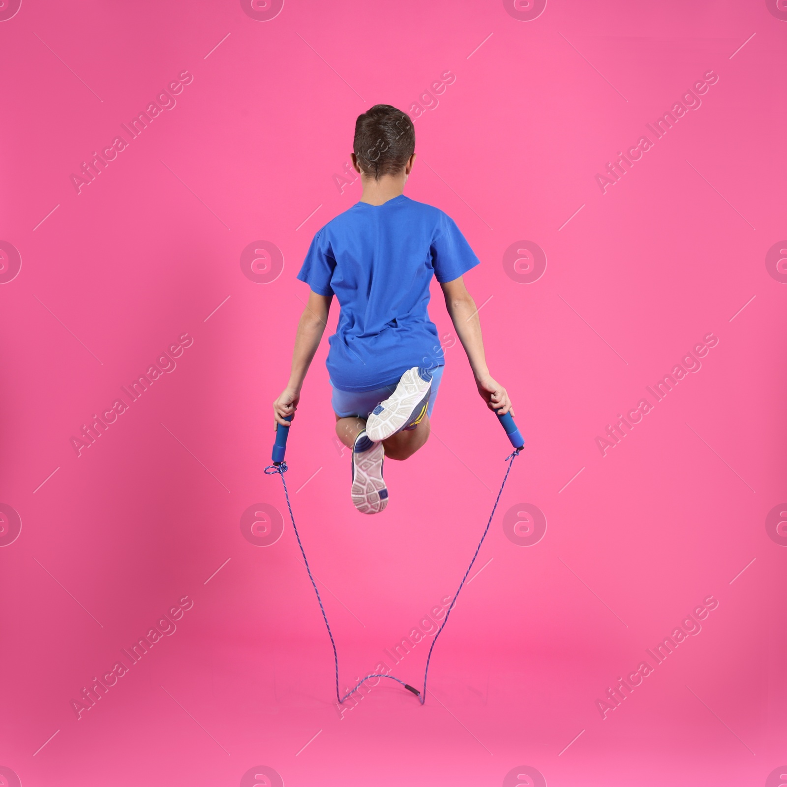 Photo of Active boy jumping rope on color background