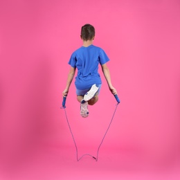 Photo of Active boy jumping rope on color background