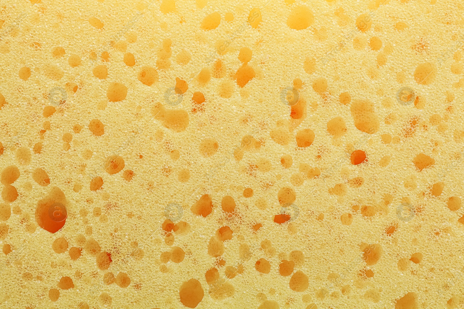 Photo of New yellow sponge as background, closeup view