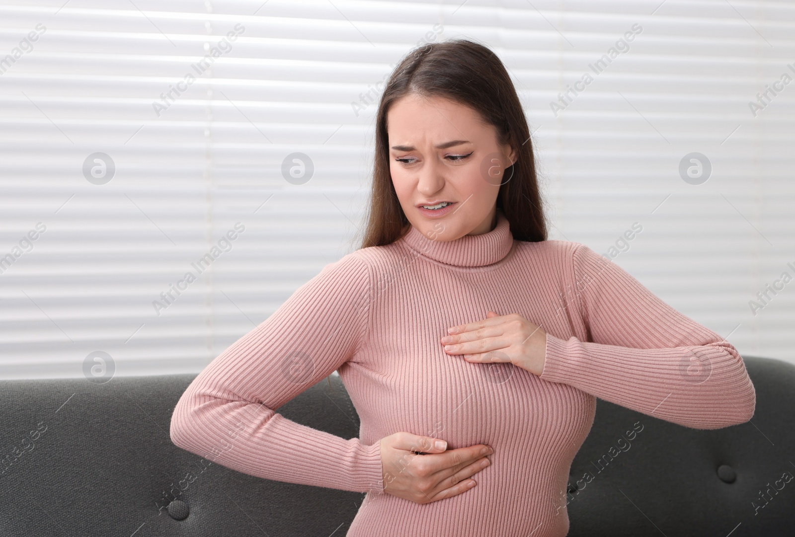 Photo of Mammology. Woman doing breast self-examination at home