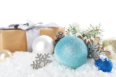 Christmas decoration with gift box on snow against white background, closeup