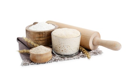Photo of Leaven, flour, rolling pin and ears of wheat isolated on white