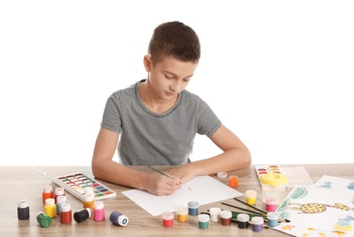 Cute child painting picture at table on white background