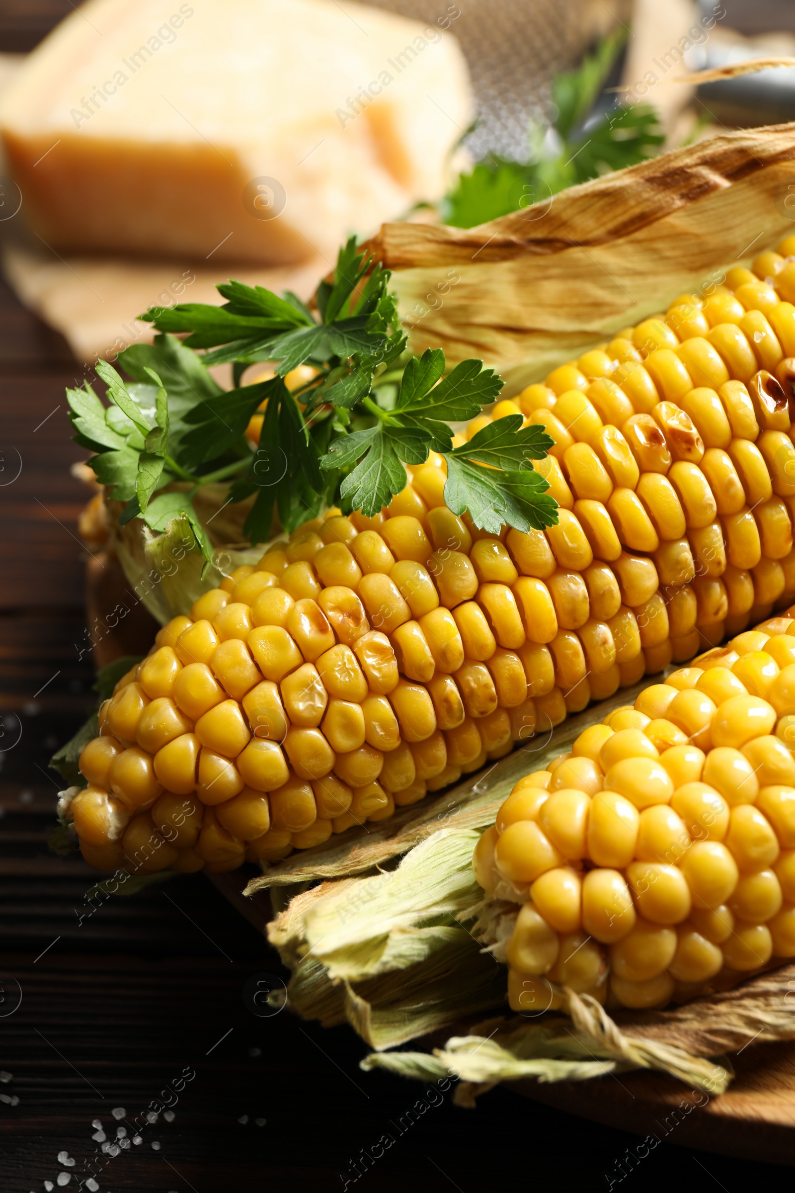 Photo of Delicious grilled sweet corn cobs on table, closeup