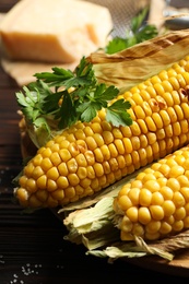 Photo of Delicious grilled sweet corn cobs on table, closeup