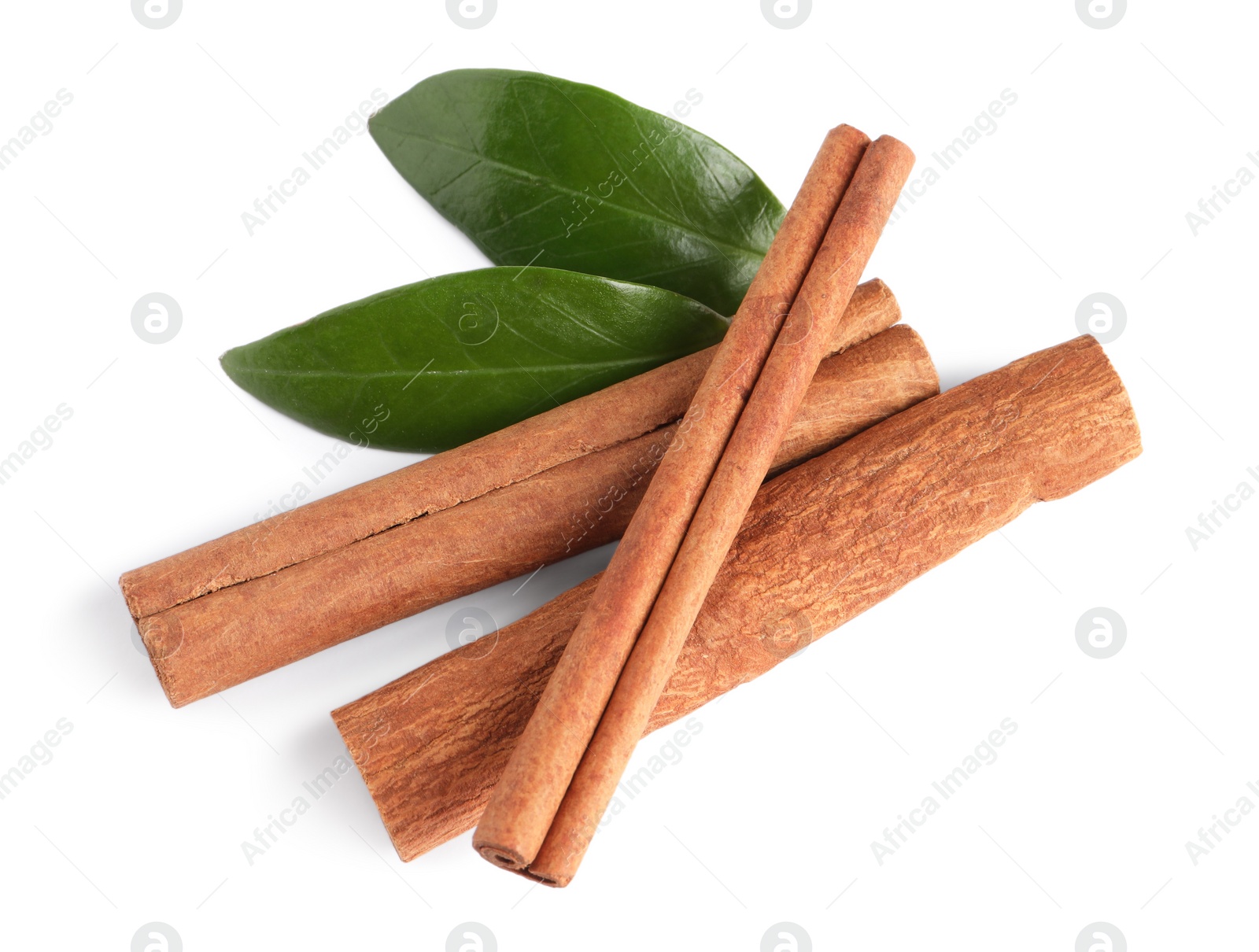 Photo of Cinnamon sticks and green leaves isolated on white, top view