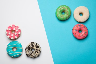 Photo of Different delicious glazed doughnuts on color background, flat lay. Space for text