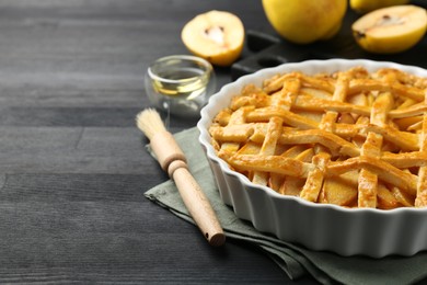 Tasty homemade quince pie and fresh fruits on black wooden table, closeup. Space for text