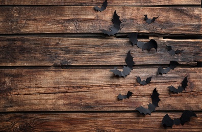 Photo of Paper bats on wooden background, flat lay with space for text. Halloween decor
