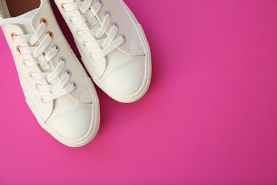 Photo of Pair of casual shoes on color background