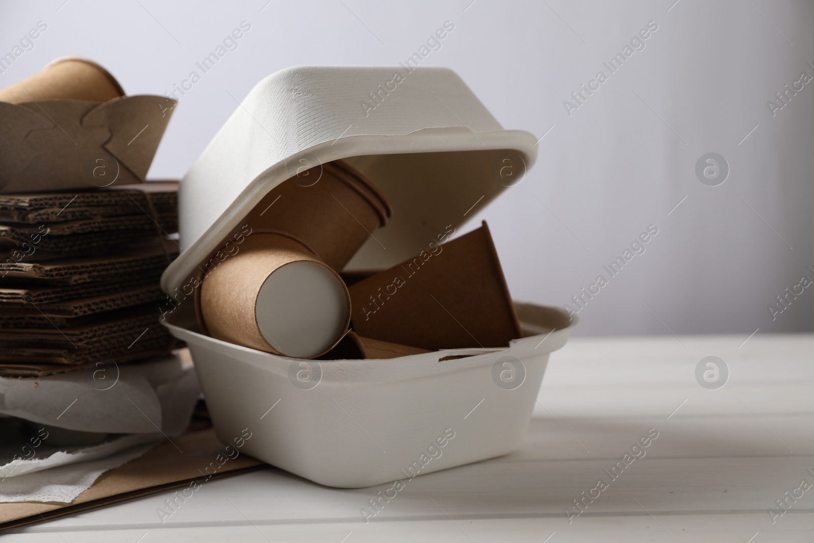 Photo of Heap of waste paper on white wooden table, space for text