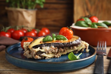 Photo of Delicious eggplant lasagna served on wooden table, closeup