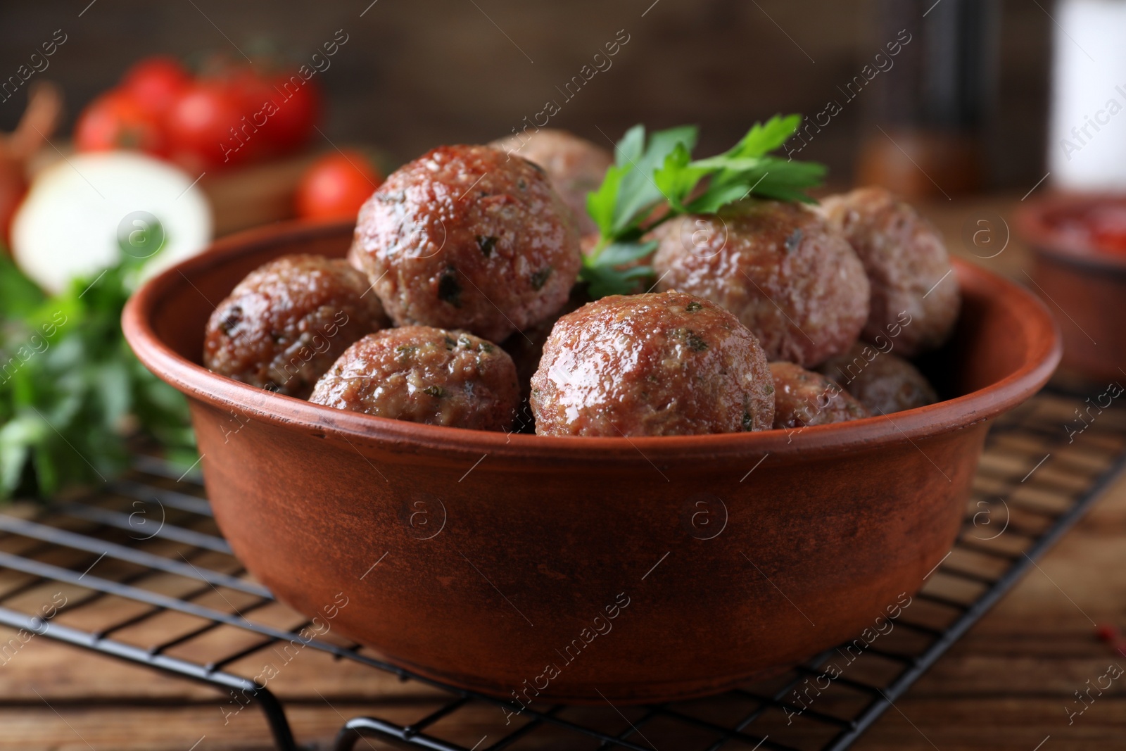 Photo of Tasty cooked meatballs with parsley on wooden table, closeup