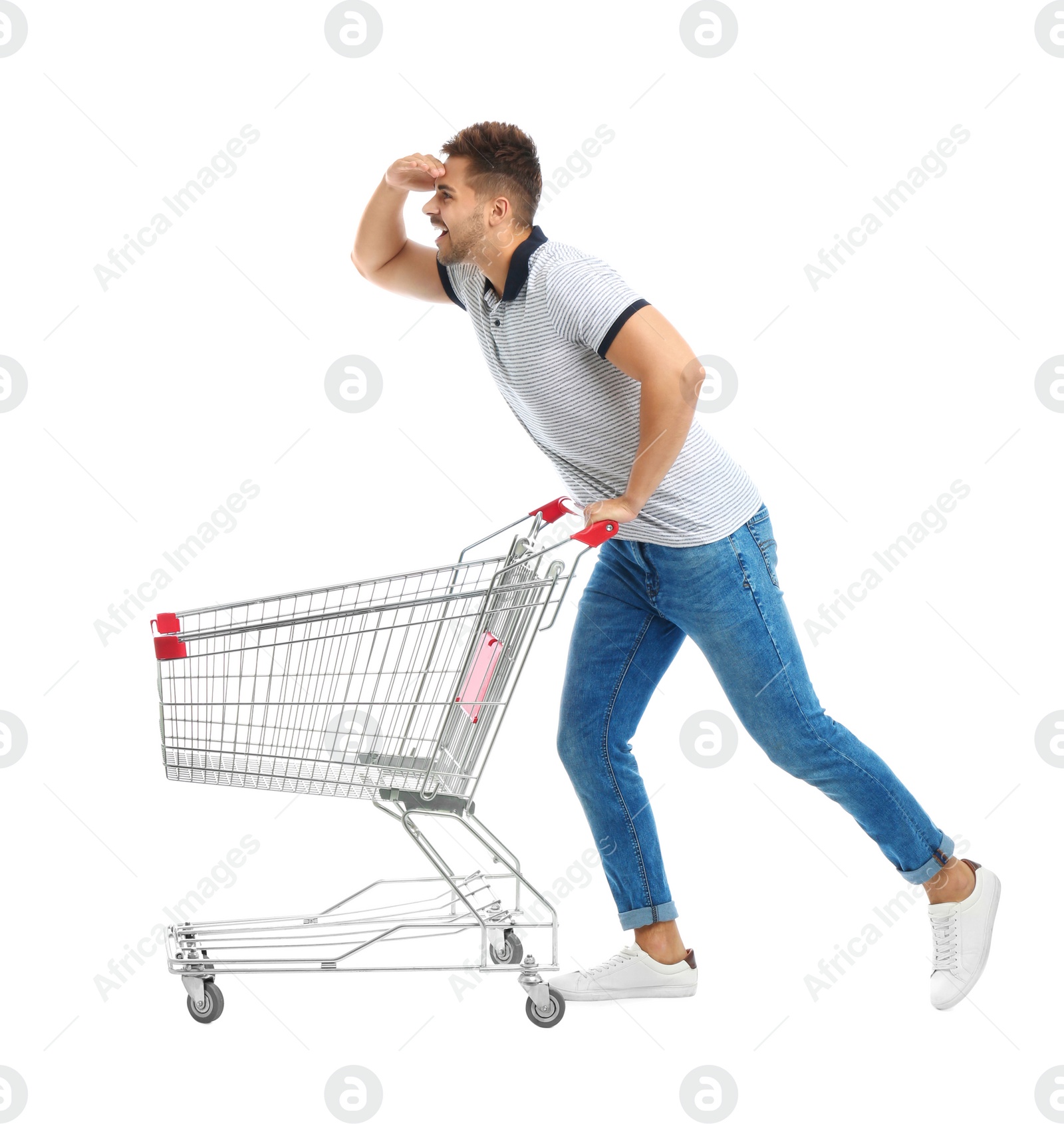 Photo of Young man with empty shopping cart on white background