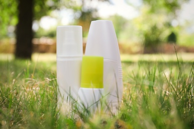 Bottles of insect repellent on green grass