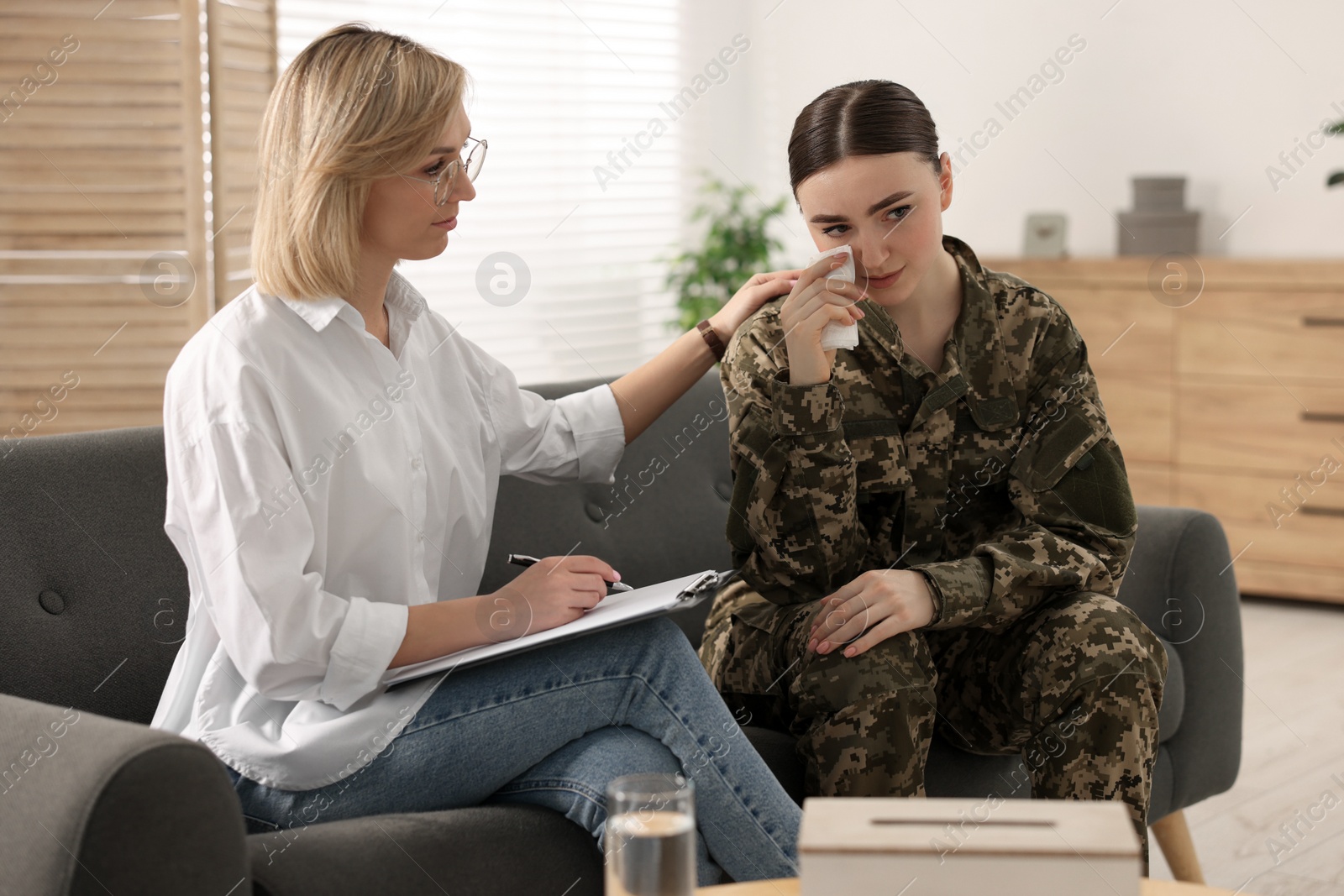 Photo of Psychotherapist working with military woman on sofa in office