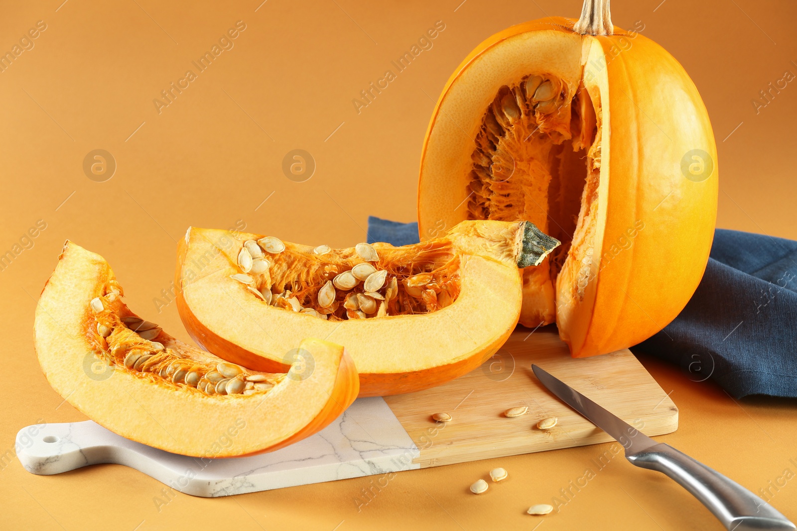 Photo of Cut fresh ripe pumpkin on orange background