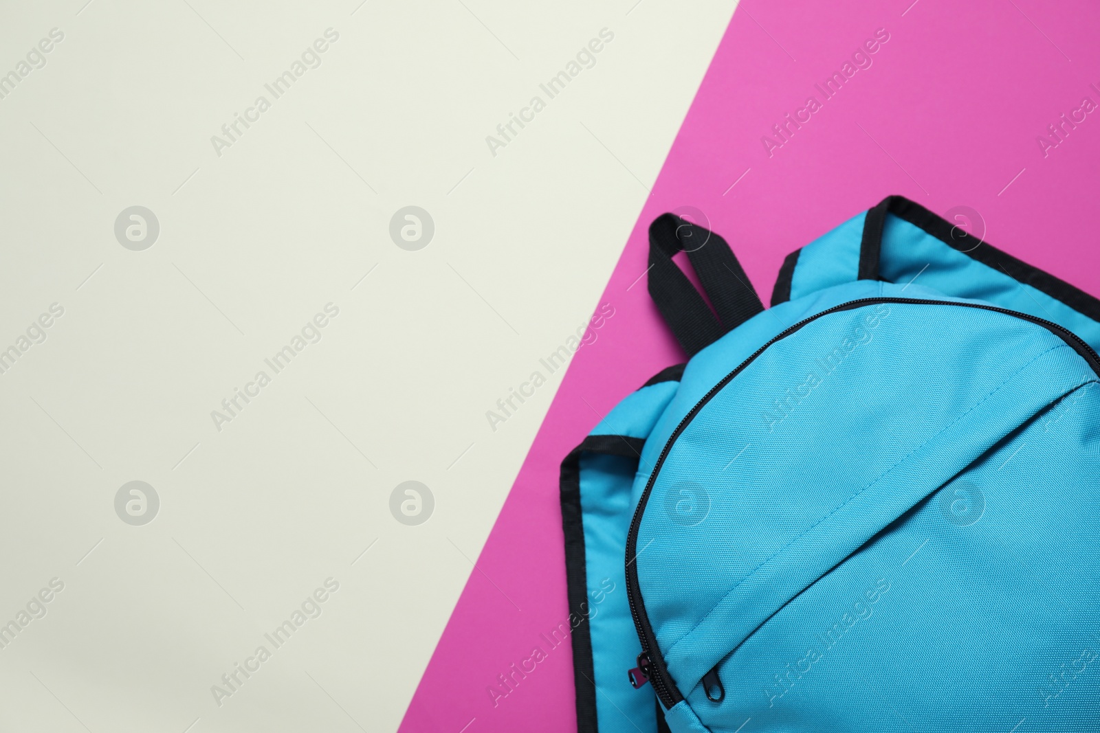 Photo of Stylish light blue backpack on color background, top view. Space for text