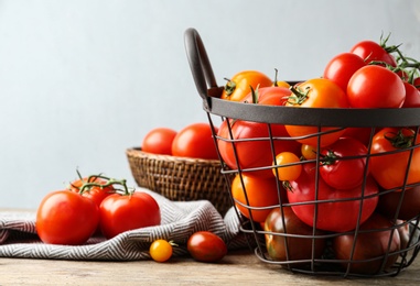 Photo of Fresh ripe tomatoes in basket on table against light background. Space for text