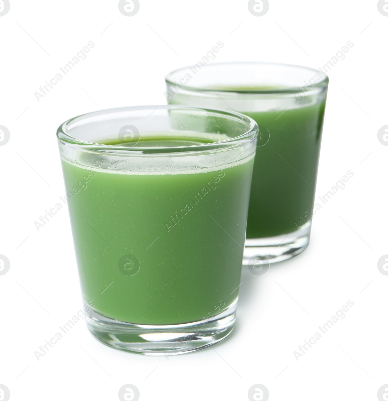 Fresh wheat grass juice in glasses on white background Photo of Fresh wheat grass juice in glasses on white background