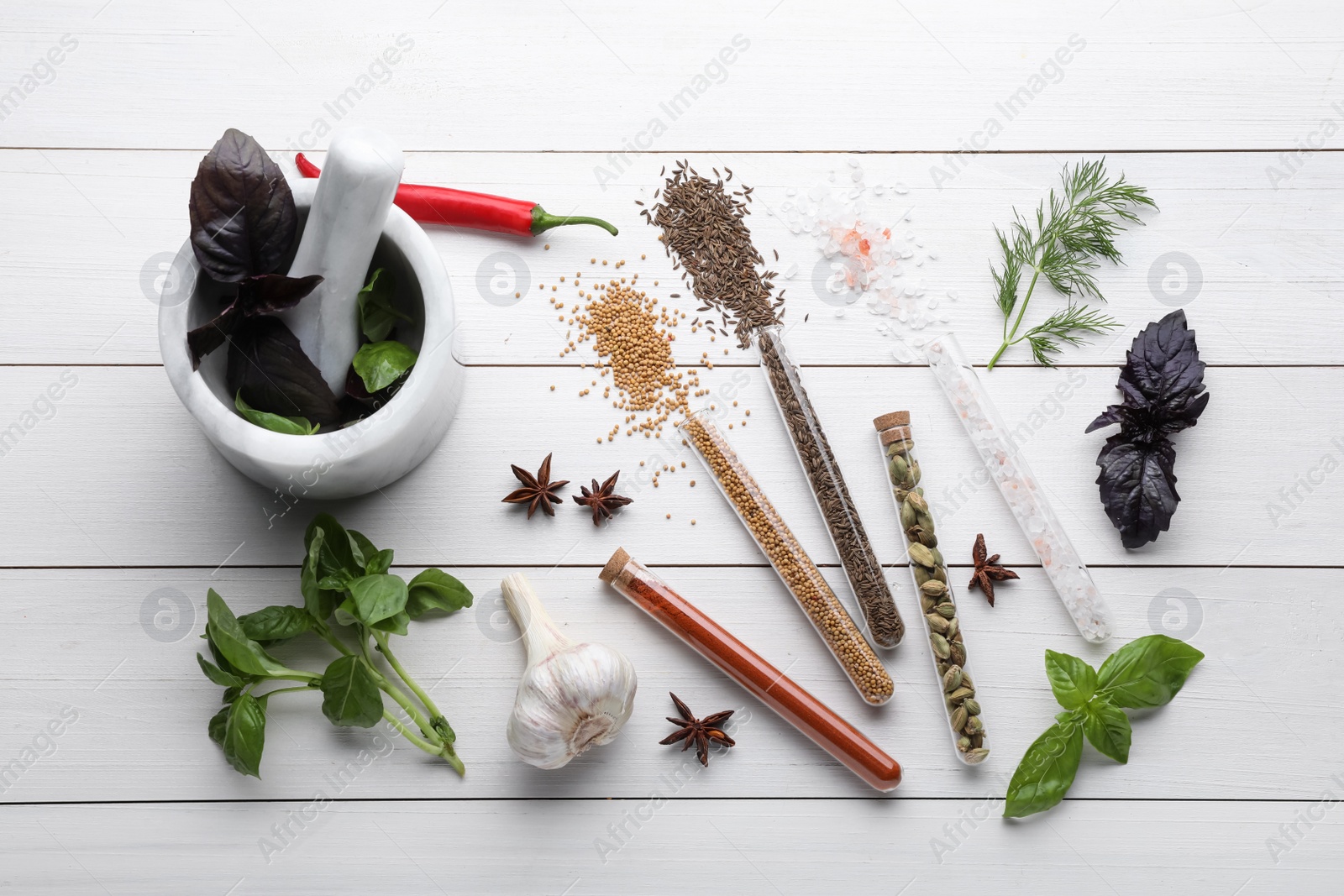 Photo of Flat lay composition with various spices, test tubes and fresh herbs on white wooden background