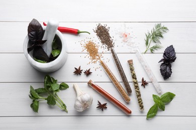 Photo of Flat lay composition with various spices, test tubes and fresh herbs on white wooden background