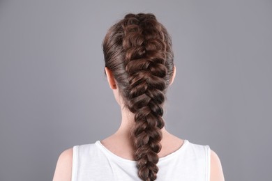 Photo of Woman with braided hair on grey background, back view