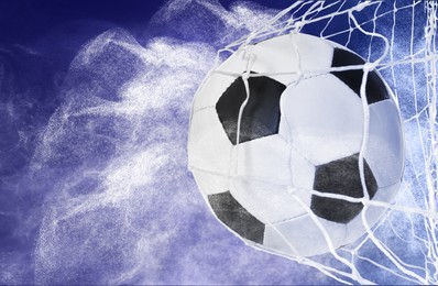 Soccer ball in net and white smoke on blue background, space for text