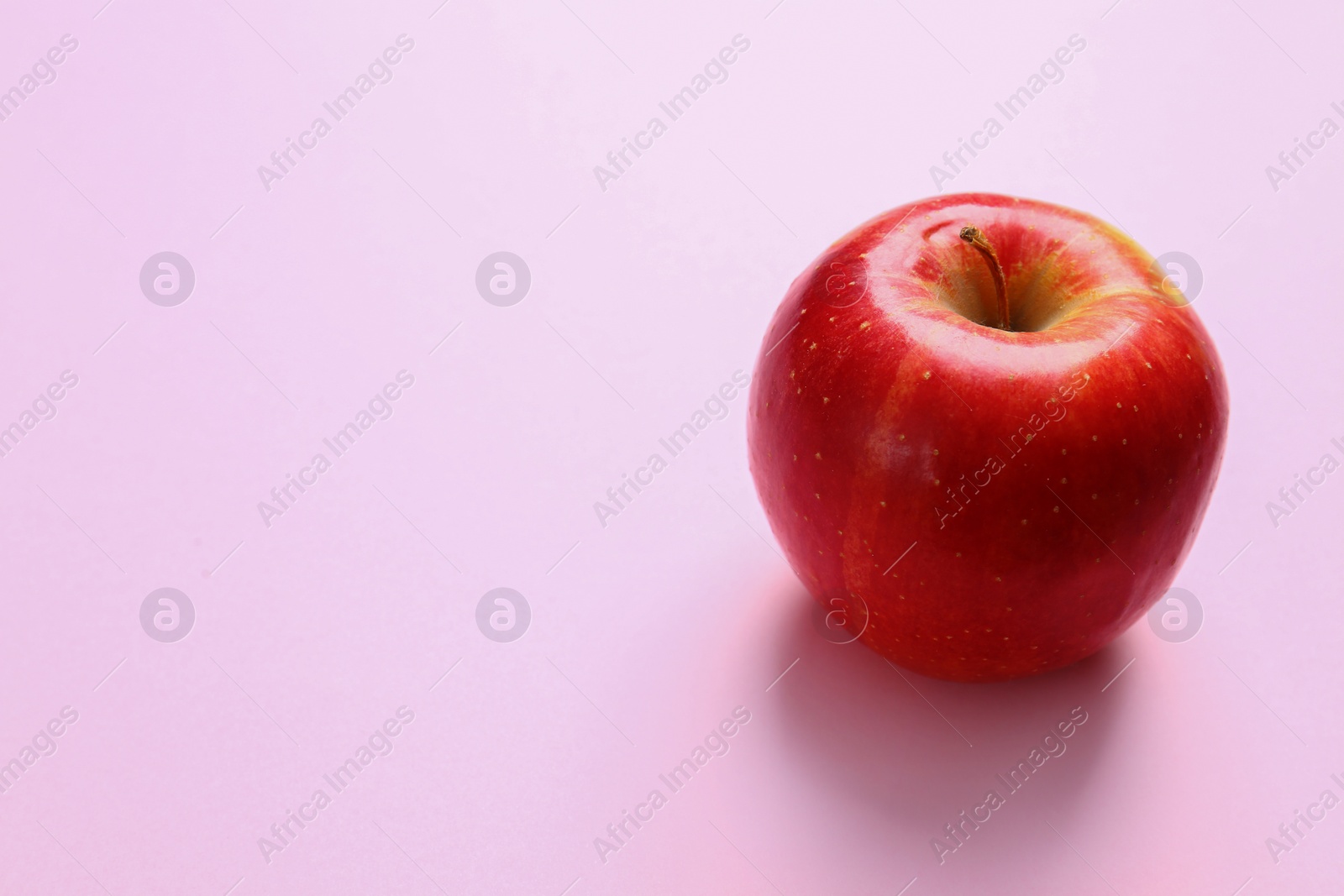 Photo of Tasty raw apple on pink background, space for text