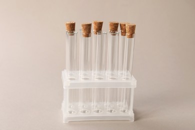 Photo of Test tubes in stand on beige background. Laboratory glassware