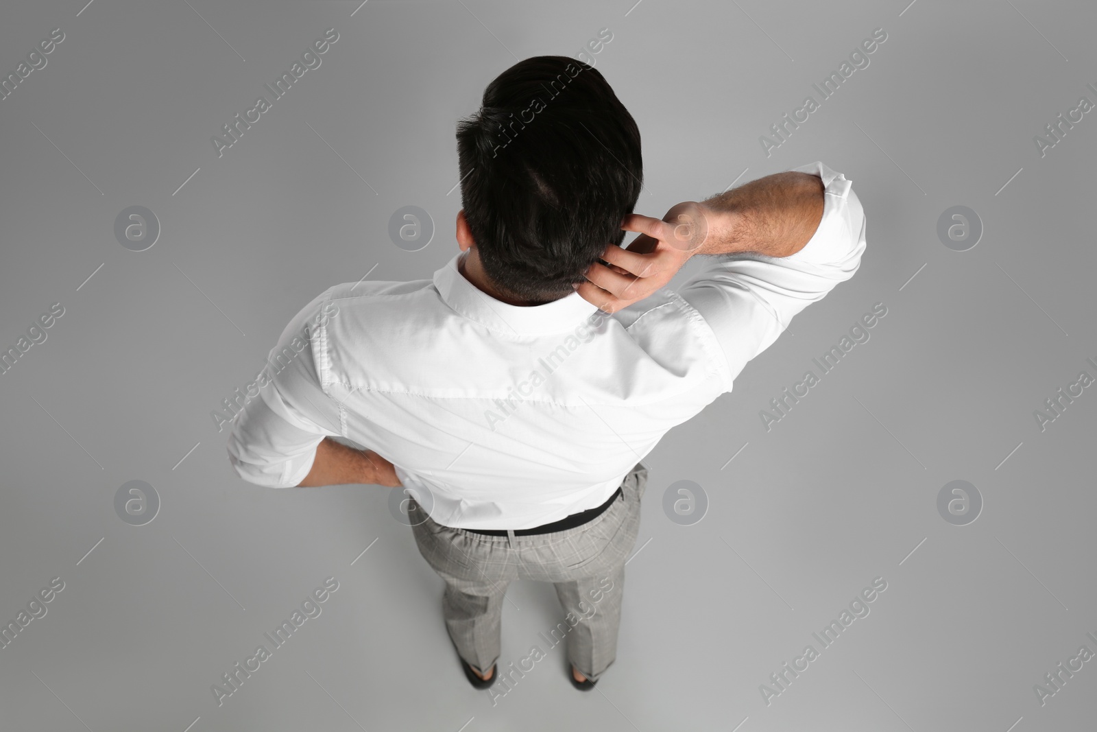 Photo of Businessman in formal clothes on grey background, back view