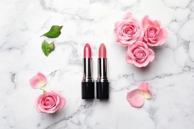 Flat lay composition with lipsticks and roses on marble background