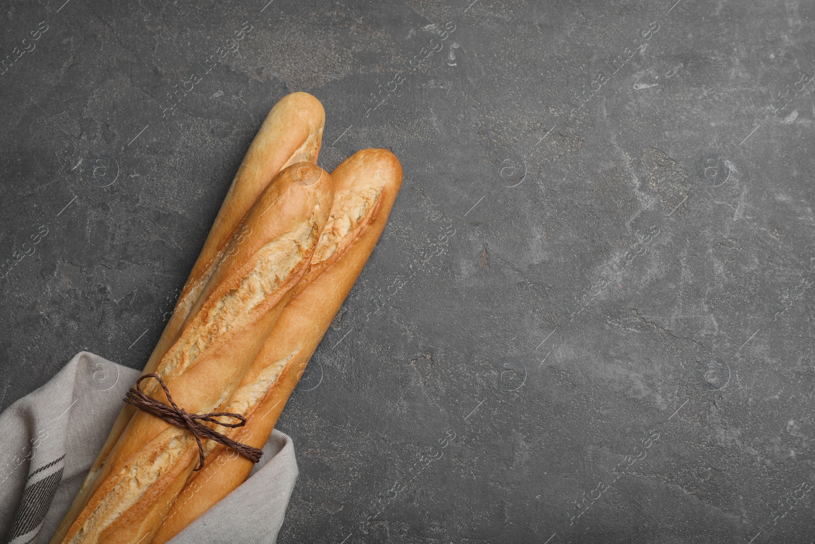 Photo of Tasty baguettes on grey table, top view. Space for text