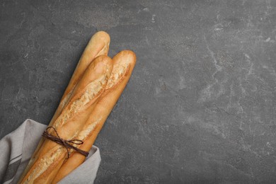 Tasty baguettes on grey table, top view. Space for text