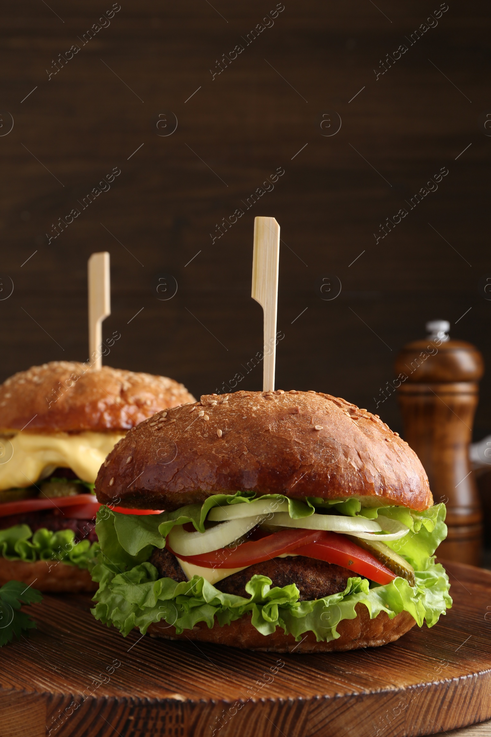 Photo of Delicious vegetarian burgers served on wooden board