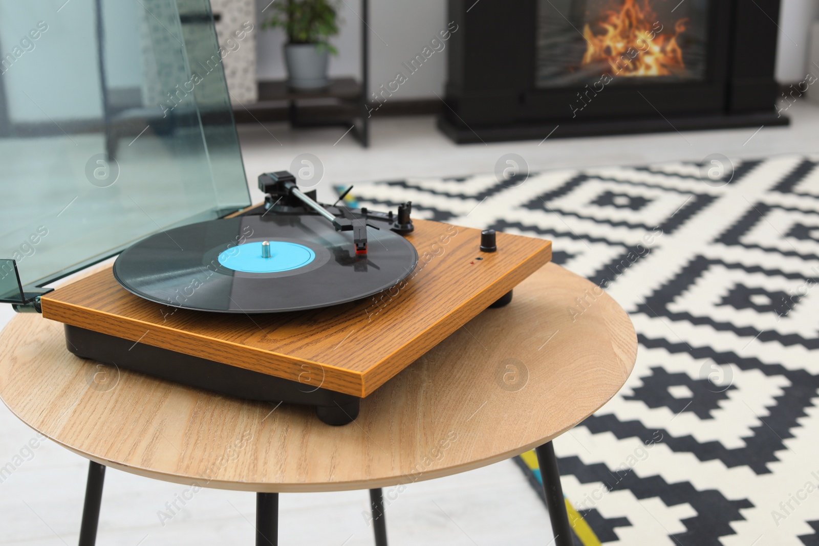 Photo of Vinyl record player on wooden table indoors. Interior element