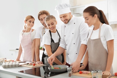 Group of people and male chef at cooking classes