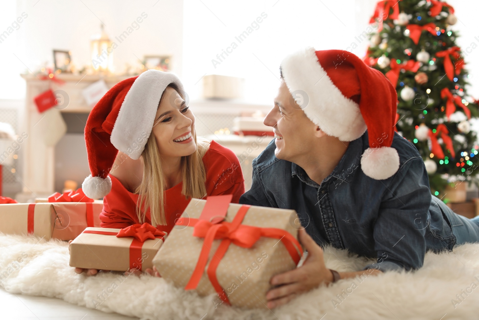 Photo of Young couple with Christmas gifts at home