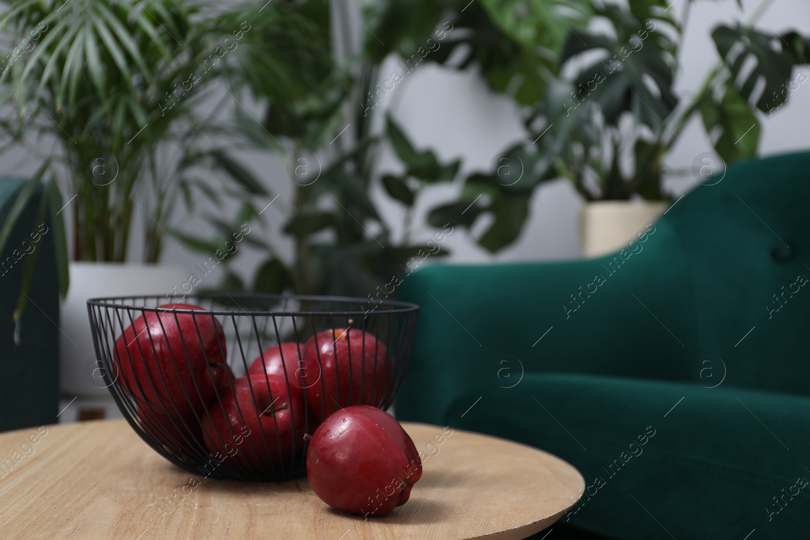 Photo of Red apples on side table in room, space for text