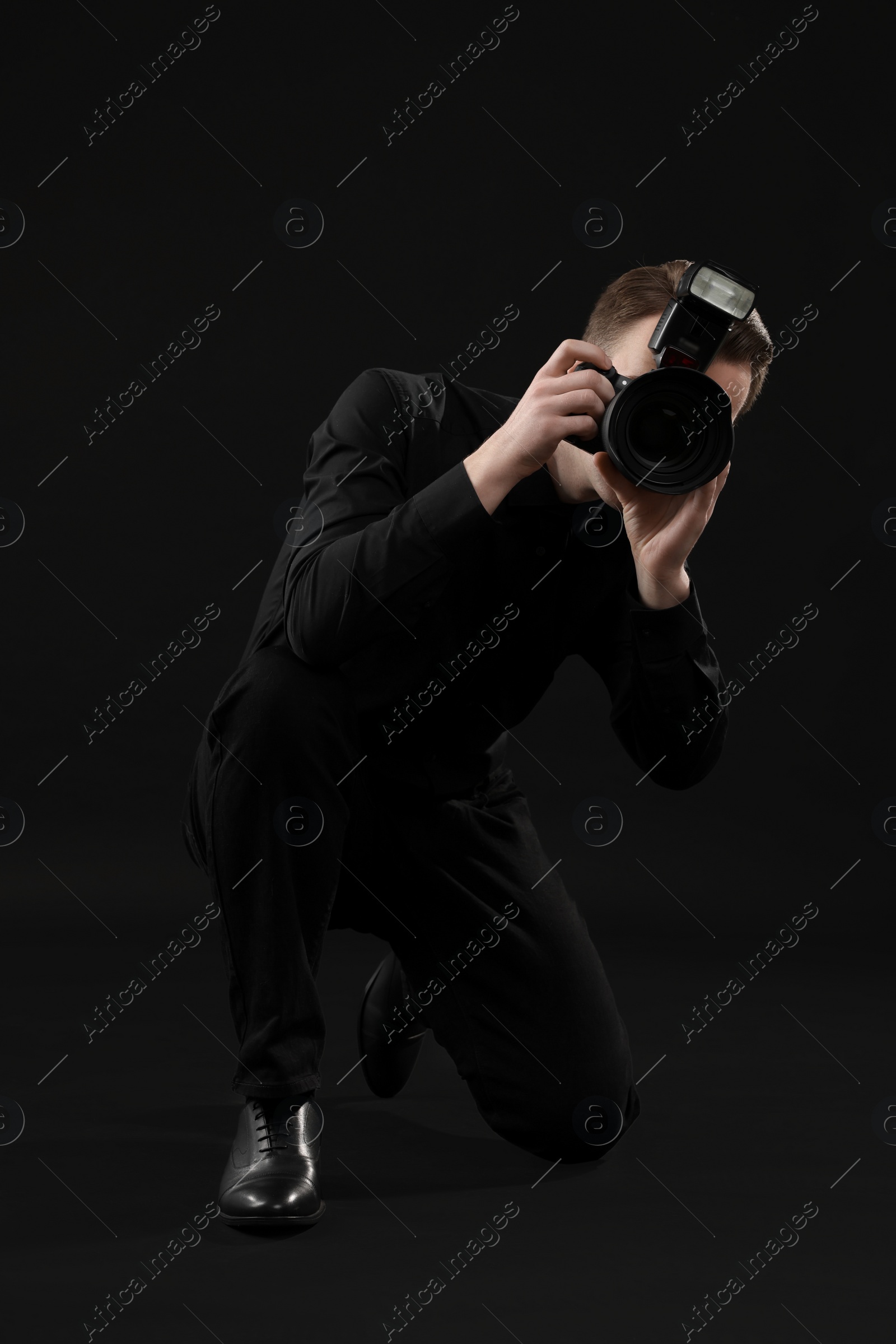 Photo of Professional photographer taking picture on black background