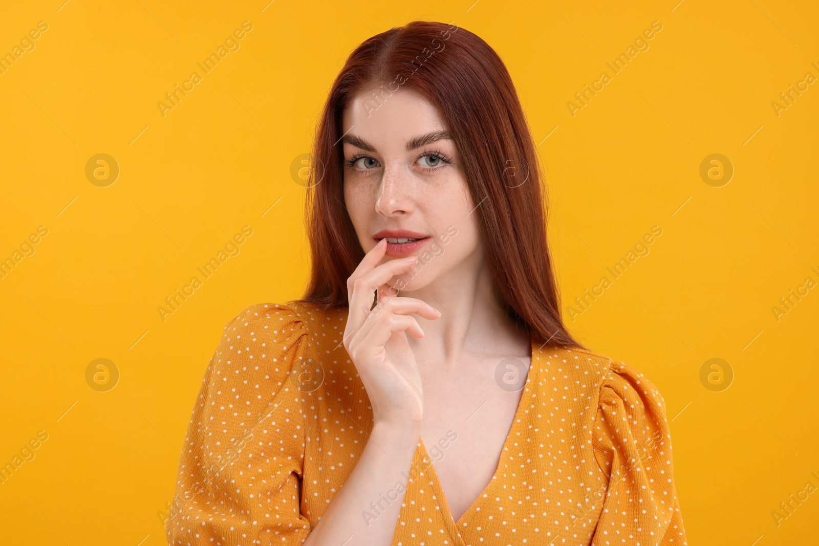 Photo of Portrait of beautiful woman with freckles on yellow background