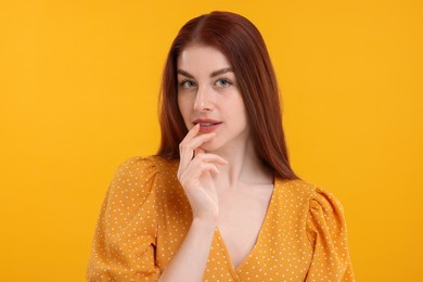 Portrait of beautiful woman with freckles on yellow background