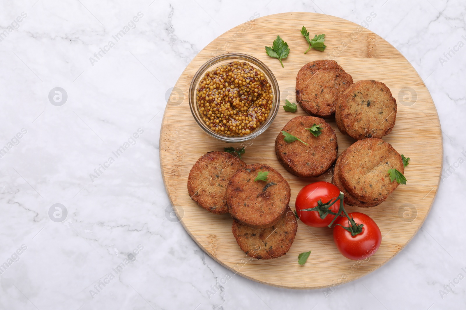 Photo of Tasty vegan cutlets, tomatoes and grain mustard on white marble table, top view. Space for text