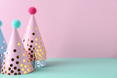 Party hats on color background, space for text