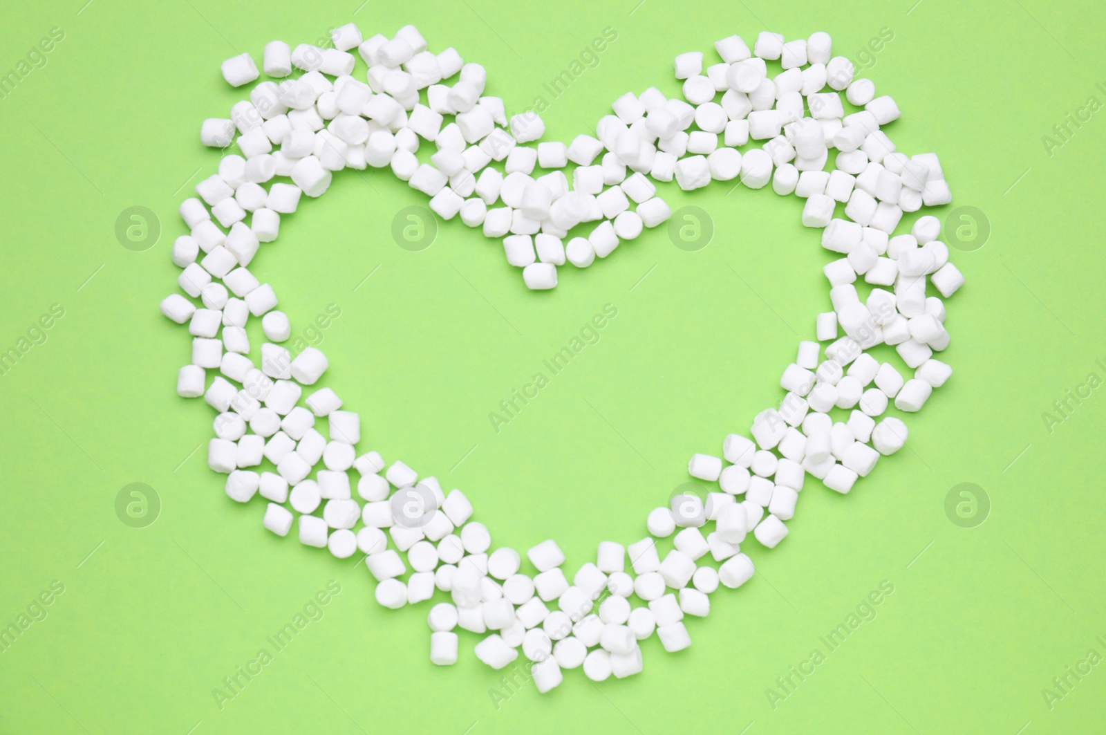 Photo of Heart made of sweet marshmallows on light green background, flat lay